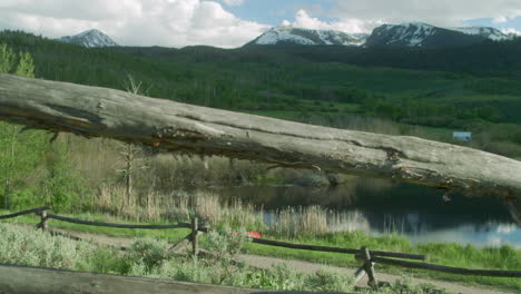 Kamera-Schiebt-Durch-Holzzaun-Malerische-Landschaft-Mit-Waldbäumen-In-Den-Schneebedeckten-Bergen-Colorados