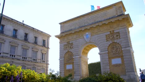Der-Triumphbogen-Von-Montpellier-Mit-Den-Strahlen-Der-Sonne-Und-Der-Französischen-Flagge,-Die-An-Seiner-Spitze-Weht