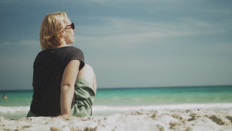 Frau-Sitzt-Am-Sandstrand,-Spielt-Mit-Dem-Sand,-Entspannter-Urlaub-Auf-Mallorca