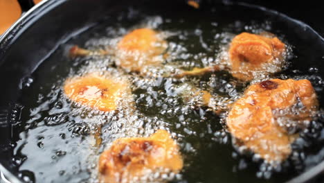 Non-vegetarian-restaurant-style-chicken-lollipop-frying-in-sizzling-hot-oil,-slow-motion-cooking-video