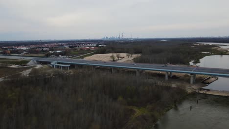 Aerial-trucking-shot-of-traffic-on-bridge-crossing-Vistula-River-during-cloudy-day