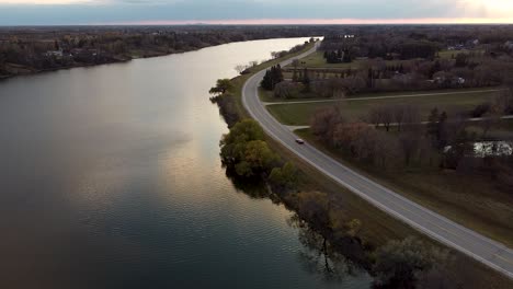 Beautiful-Water-Reflection-Corvette-Driving-Down-Riverside-Road