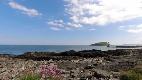 Rocky-boulder-lighthouse-beach-coastline-time-lapse-relaxing-blue-sky-island-landscape