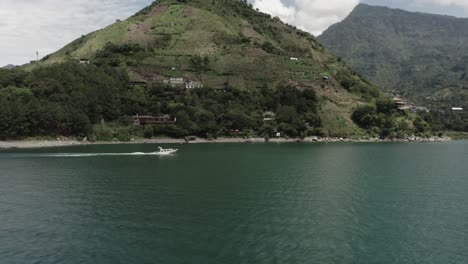 Motorboat-sails-along-coast-of-Atitlan-lake,-Guatemala