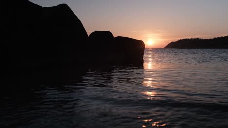 Sunrise-over-a-sea-with-rocks-in-foreground