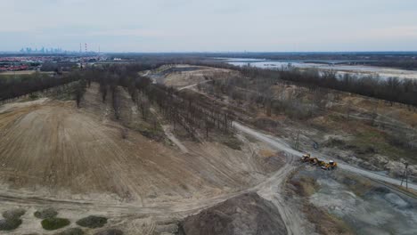 Aerial-view-of-sand-mining-region-beside-river-and-industrial-factory-in-background