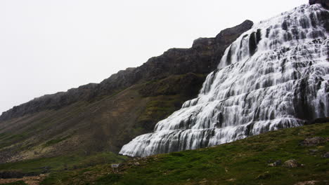 Massive-waterfall-on-mountain-slope-in-Iceland,-pan-right-view