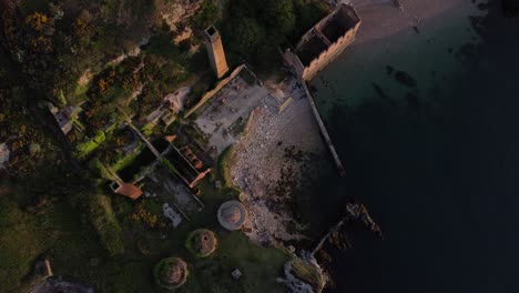 Porth-Wen-abandoned-coastal-derelict-brickworks-remains-golden-sunrise-countryside-bay-aerial-birdseye-view-static