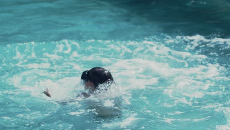 Fröhlicher-Junge-Mit-Brille,-Der-An-Warmen-Sommertagen-Ins-Schwimmbad-Springt