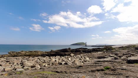 Sunny-rocky-lighthouse-beach-coastline-getaway-time-lapse-relaxing-blue-sky-island-landscape