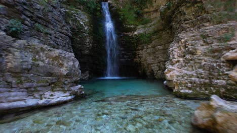 Beautiful-waterfall-with-emerald-water-surrounded-by-high-rocks-in-Albania
