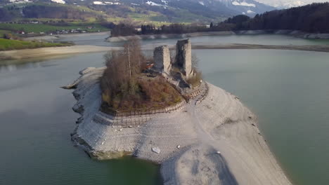 Aerial-circling-over-old-ruins-of-Pont-en-Ogoz-castle-on-Gruyere-lake