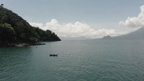 Isolierter-Mann-Auf-Einem-Boot,-Das-Auf-Dem-Atitlan-see-Schwimmt,-Mit-Dem-Vulkan-San-Pedro-Im-Hintergrund,-Guatemala