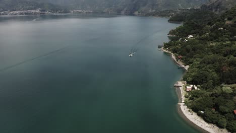 Atitlan-lake-in-Guatemala-and-boat-navigating-along-shore