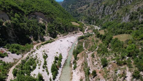 Creek-water-streaming-through-wilderness-valley-and-rocky-mountains-in-Tepelena,-Albania
