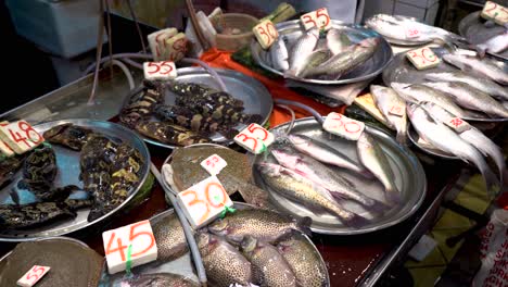 Vielzahl-Von-Lebenden-Fischen-Mit-Preisschildern,-Die-Auf-Dem-Nassen-Fischmarkt-In-Hongkong-Verkauft-Werden