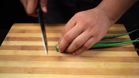 cutting-scallions,-green-onion,-spring-onion,-chives,-leeks-,-shallot-on-a-chopping-board-by-the-chef-4k-resolution,-chopping-vegetables-by-the-chef-macro-view