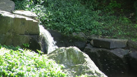 Water-cascading-down-rock-lined-channel-in-garden