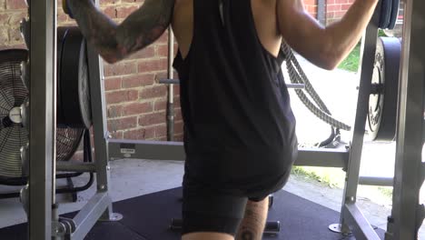 Muscly-man-in-home-gym-exercising-shot-from-back-calf-raise-smith-machine