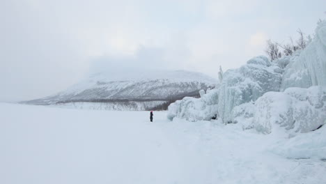 Mädchen-Zu-Fuß-Von-Einem-Großen-Eisberg-Auf-Einem-Zugefrorenen-See-In-Björkliden,-Schweden
