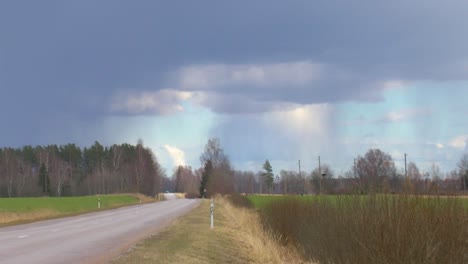 Asphalt-road-in-the-countryside,-thunder-visible-in-the-sky