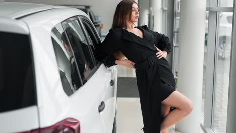 A-young-girl-in-a-dress-looks-out-the-window-of-a-new-car