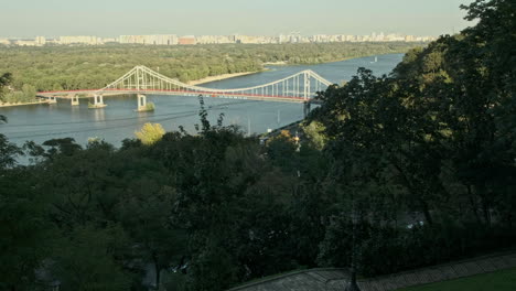 Elevated-view-of-the-Dnipro-Pedestrian-Bridge-on-a-a-warm-autumn-evening-in-Kiev