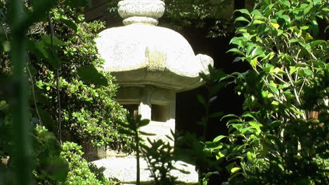 A-Japanese-stone-lantern-hidden-amidst-plants-in-a-Japanese-garden
