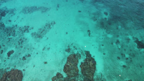 Reverse-flyover-above-Jinek's-Bay,-natural-marine-reserve-Lifou,-New-Caledonia