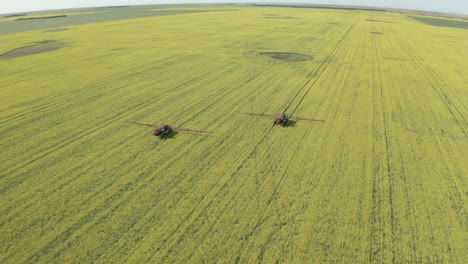 Tractors-Spraying-Fungicide-On-Canola-In-Green-Field-At-Countryside-Of-Canada