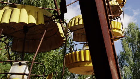 Yellow-baskets-of-Ferris-wheel-in-Pripyat,-tilting-up-view