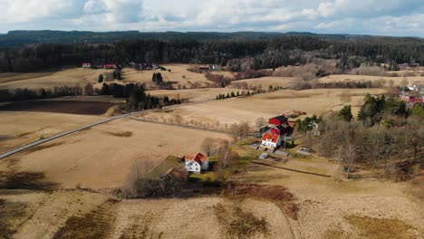 Aerial---High-angle-view-of-a-farm-and-its-surrounding-fields-in-Sweden