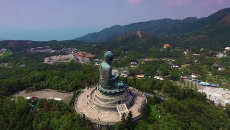 Aerial-orbit-around-Tian-Tan-Buddha-famous-statue-on-top-of-hill-at-Lantau-Island,-Hong-Kong