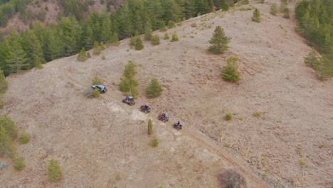 Aerial:-4WD-vehicles-and-quad-bikes-driving-up-mountain-tracks,-4K-drone-footage