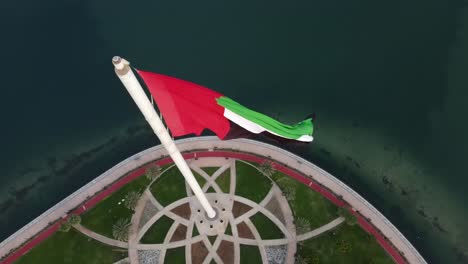 4k:-Impresionante-Dron-De-Cerca,-Bandera-De-Los-Emiratos-árabes-Unidos-Ondeando-En-El-Viento-Sobre-La-Isla-De-La-Bandera-De-Sharjah,-Emiratos-árabes-Unidos,-Video-4k