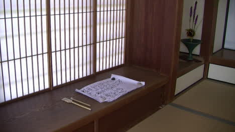 A-scroll-of-calligraphy-rests-on-a-shoji-desk-in-a-Japanese-house