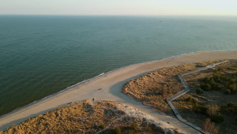 Tourists-On-Beachfront-With-Coastal-Boardwalk-In-Peninsula-Hel-Beach,-Baltic-Sea,-Poland