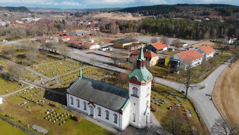 Aerial-drone-flyover-Björketorp-Church-and-cemetery-in-Rävlanda,-Sweden