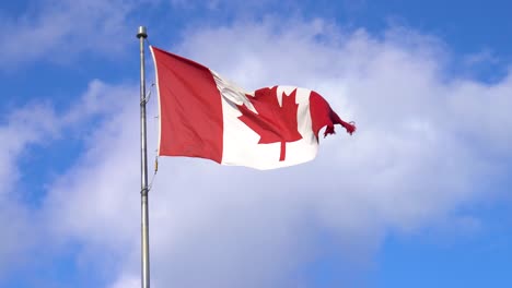 Kanadische-Ahornblattflagge-Weht-Im-Wind-Mit-Blauem-Himmel-Und-Wolken