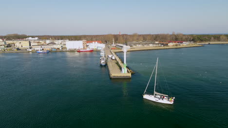 Aerial-shot-of-sailing-boat-arrving-Port-of-Peninsula-Hel-during-sunny-day-in-Poland