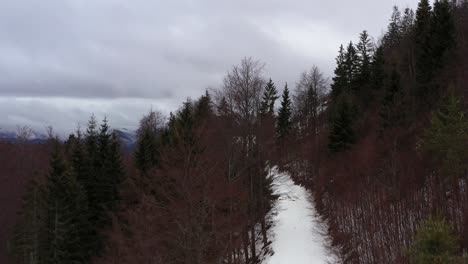 Aerial-mountain-shot-revealing-winter-landscape-beyond