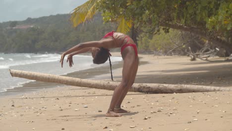 Contortionist-bikini-girl-bends-into-a-contortion-position-in-the-sand-of-an-amazing-beach-location