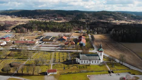 Aerial---Björketorps-Church-and-burial-ground,-Rävlanda,-Sweden,-wide-shot