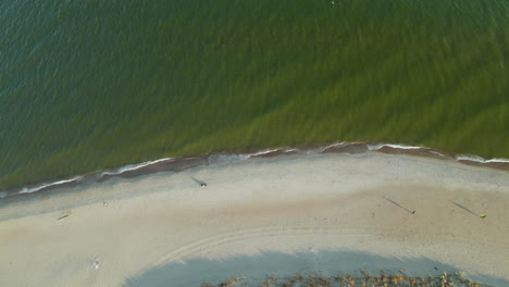Aerial---drone-takeoff-over-Baltic-sea-and-white-sand-beach-in-Hel-peninsular-Poland