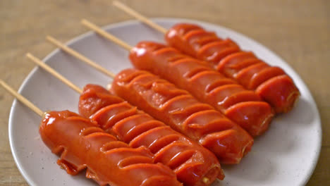 fried-sausage-skewer-on-white-plate