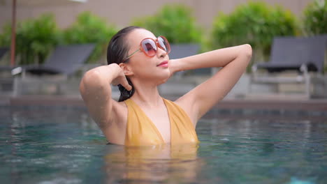 Beautiful-Asian-Woman-in-Swimming-Pool-Enjoying-Me-Time,-Slow-Motion