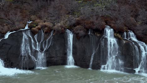 Hraunfossar-Waterfall-Pouring-Down-From-Low-Ledges-Of-Volcanic-Rock-To-Hvita-River-Through-Hallmundarhraun-Lava-Field,-Creating-Beautiful-Landscape