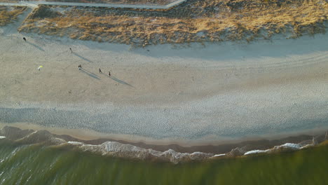 People-Flying-Kite-On-Sandy-Seaside-In-Hel-Peninsula-Beach,-Baltic-Sea,-Poland