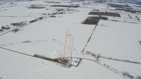 Aerial-view-of-windmill-construction-in-winter-with-snow-landscape