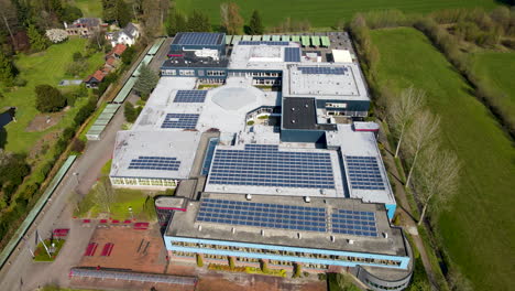 Flying-over-large-high-school-with-solar-panels-on-rooftop